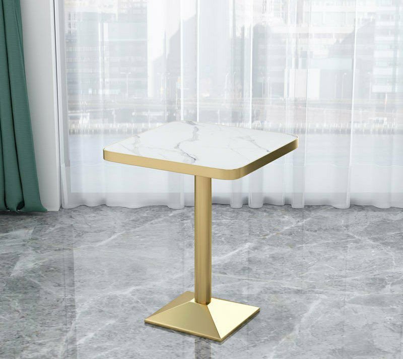 Table ronde et carree moderne de style bistrot ou d'appoint, dotée d'un plateau effet marbre blanc et d'un pied central tubulaire avec une base évasée de couleur dorée.